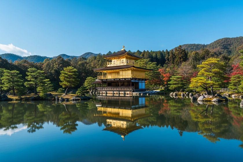 Kinkaku-ji Golden Pavilion in Kyoto reflected in a calm pond, clear blue sky, autumn greenery, iconic Japanese temple, high resolution travel photo